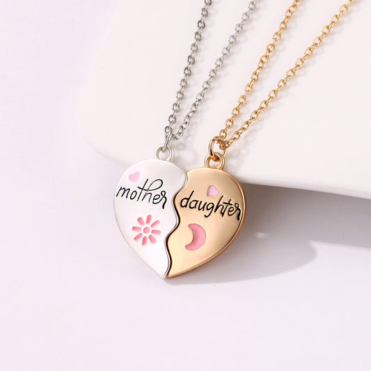 A two-piece heart-shaped necklace set with "Mother" on a silver pendant and "Daughter" on a gold pendant, featuring pink heart and moon details.