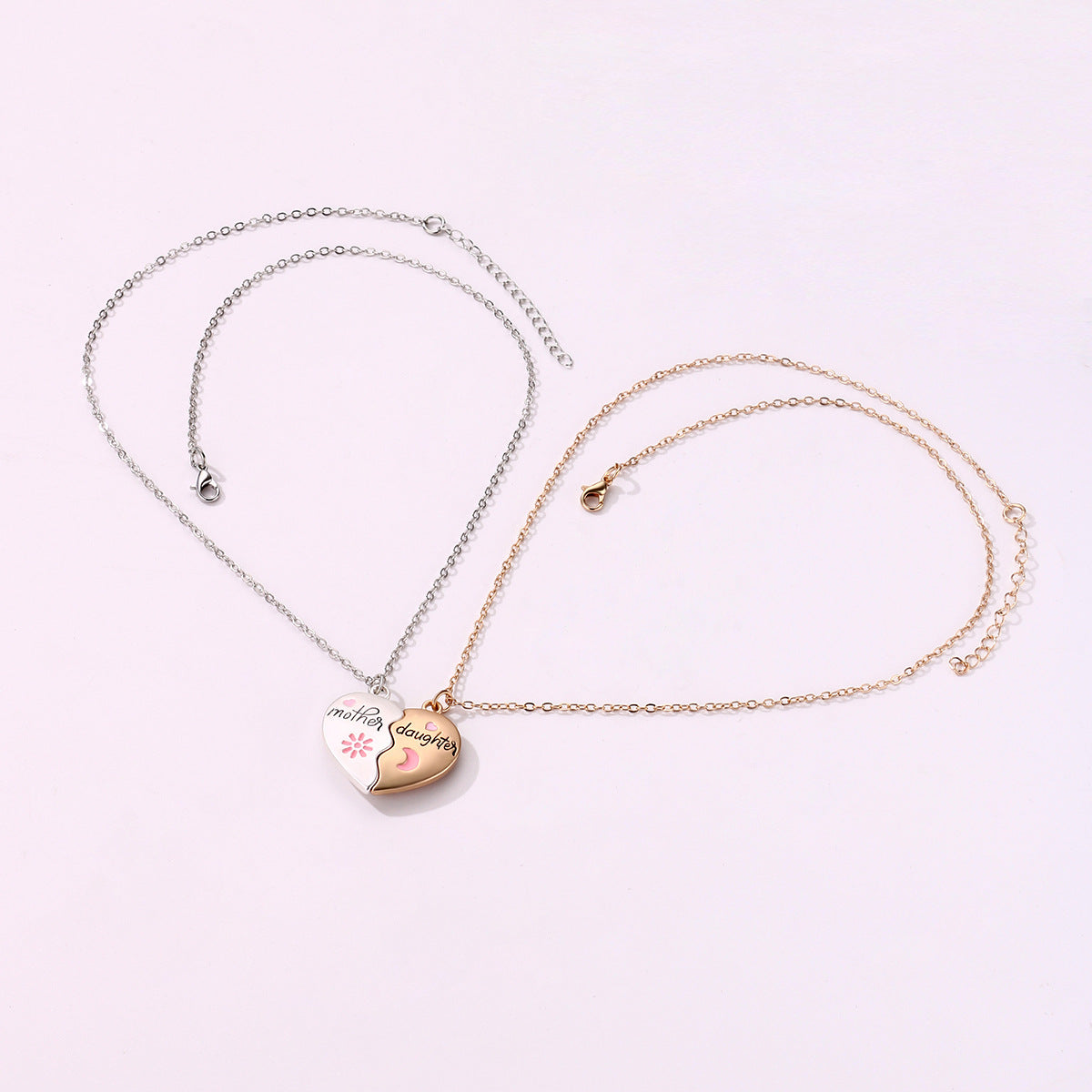 A two-piece heart-shaped necklace set with "Mother" on a silver pendant and "Daughter" on a gold pendant, featuring pink heart and moon details - full view of necklace set with chains