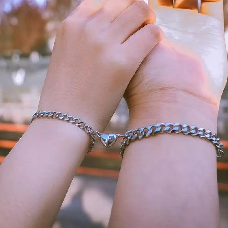 Steel Bond Heart Couple Bracelet – Magnetic steel bracelets with a bonded heart design, symbolizing love and connection in a sleek, durable style for couples. couple wearing bracelet while holding hands - close up view