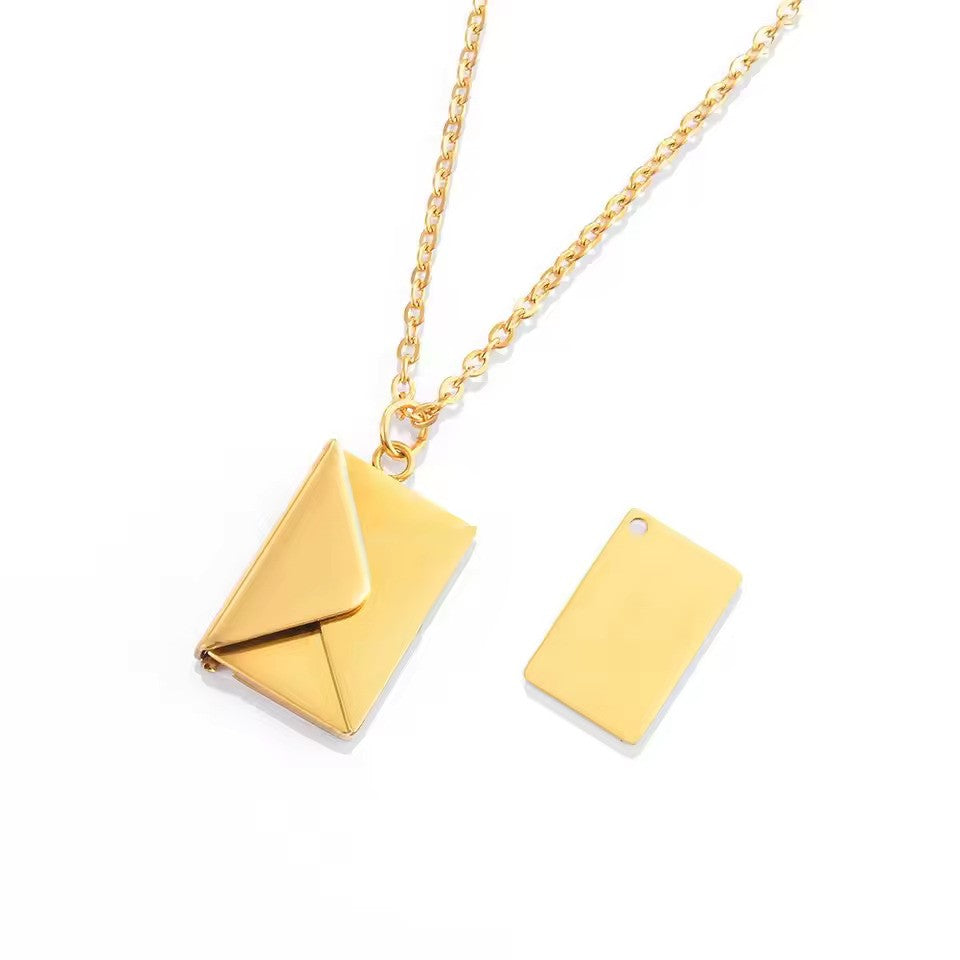 A gold Custom Engraved Love Letter Necklace with a sleek envelope design, elegantly displayed on a delicate matching chain.