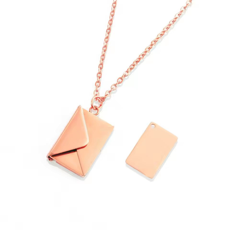 A rose gold Custom Engraved Love Letter Necklace with a warm-toned envelope design, beautifully hanging from a delicate chain.
