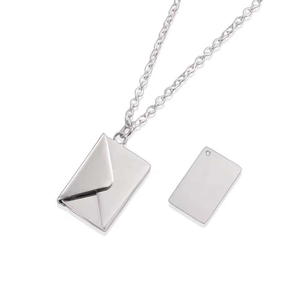 A silver Custom Engraved Love Letter Necklace featuring a polished envelope pendant, paired with a stylish silver chain.